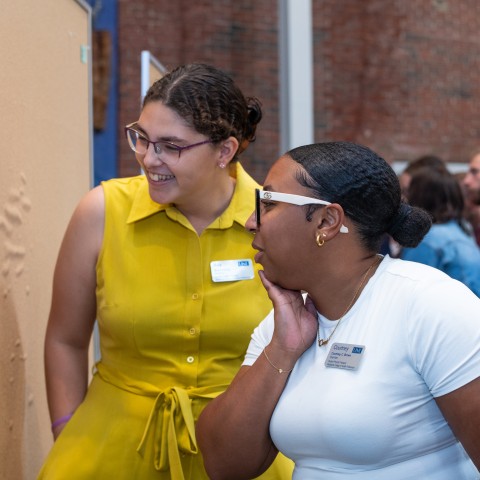 two students engage with questions on sticky notes