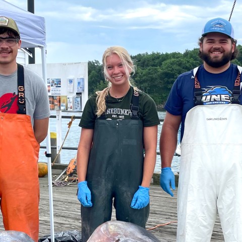 Three marine science students pose on the pier at Camp Ellis along the Saco River