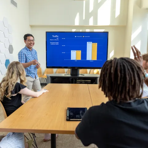 person lectures in front of students in college of business