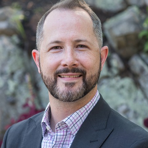 Headshot of Kiernan Gordon against a blue banner