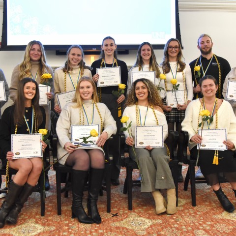 A group of occupational therapy students poses wearing their honor cords