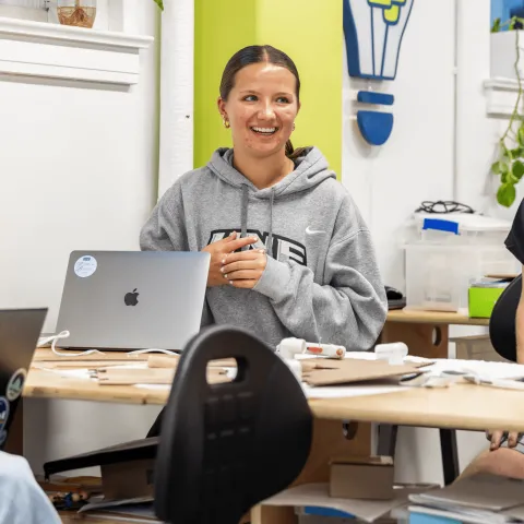 Three UNE students work around a table in the Makerspace