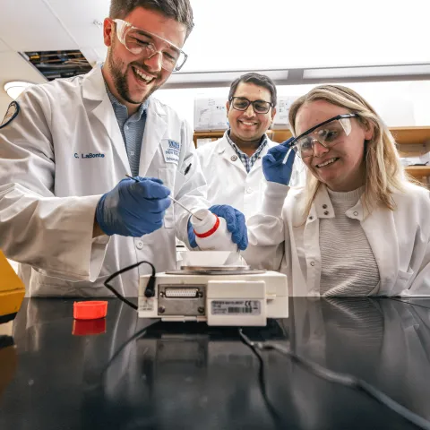 UNE faculty member Sri Mohan works with students in his lab